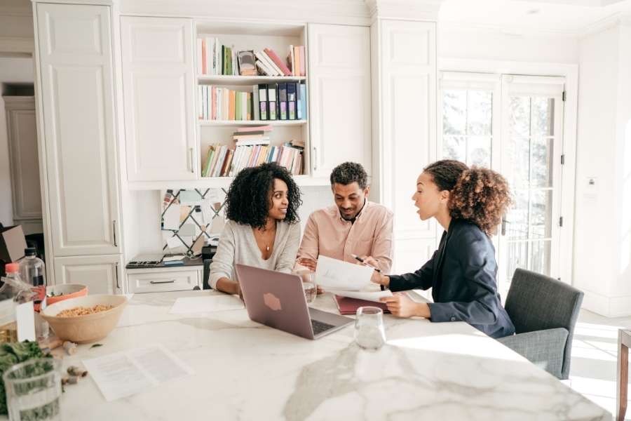 Un couple consulte un conseiller professionnel pour évaluer la Rentabilité nette de votre bien immobilier.