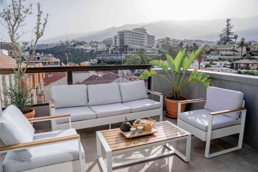 Un salon de jardin moderne sur une grande terrasse avec vue panoramique pour l'aménagement de son balcon.